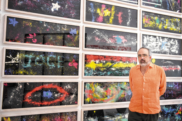 OBRA. El artista posa frente a las obras que realizaron los niños durante su taller. Foto: Leslie Pérez.