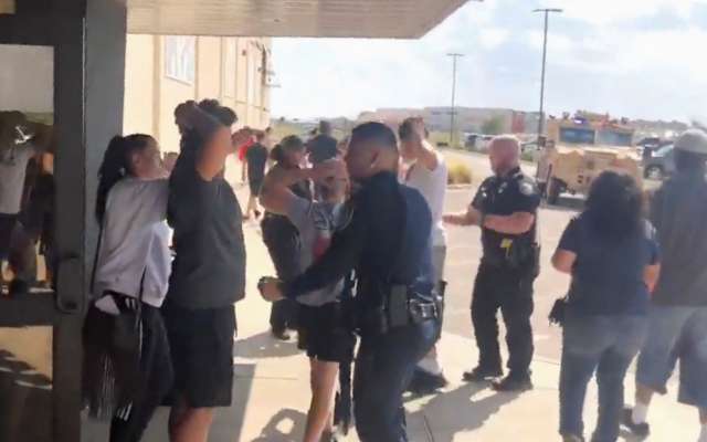PRECAUCIÓN. Agentes de la Policía evacuaron a personas del cine Cinergy Odessa, luego del ataque. Foto: REUTERS